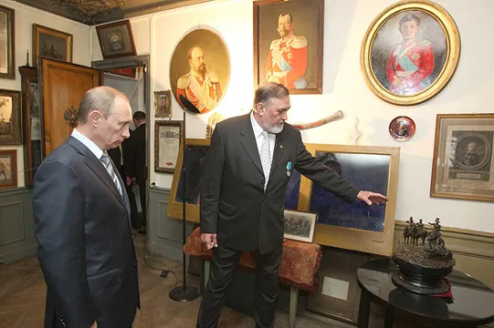 Au musée des Cosaques de la Garde, à Courbevoie : le conservateur présente la collection à Vladimir Poutine. 30 mai 2008. Photo : premier.gov.ru (Wikimedia Commons, CC BY 4.0).